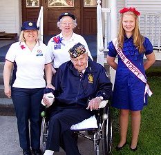 J Petersen and S Witchella of Auxiliary, and Miss Poppy stand beside vet Bud Mohr. 